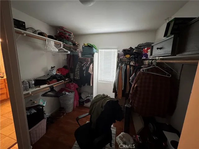 a view of walk in closet with clothes and shoes