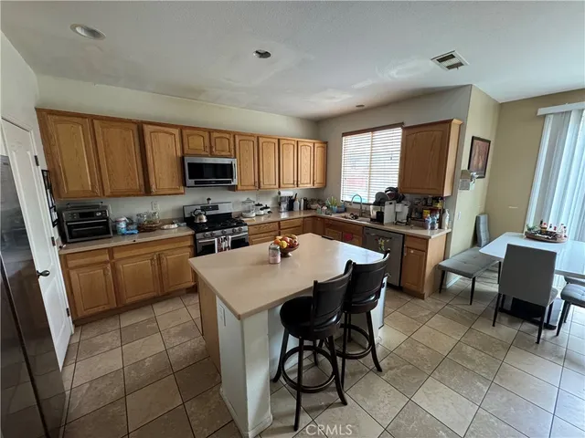 a kitchen with a sink a counter top space a large window and stainless steel appliances