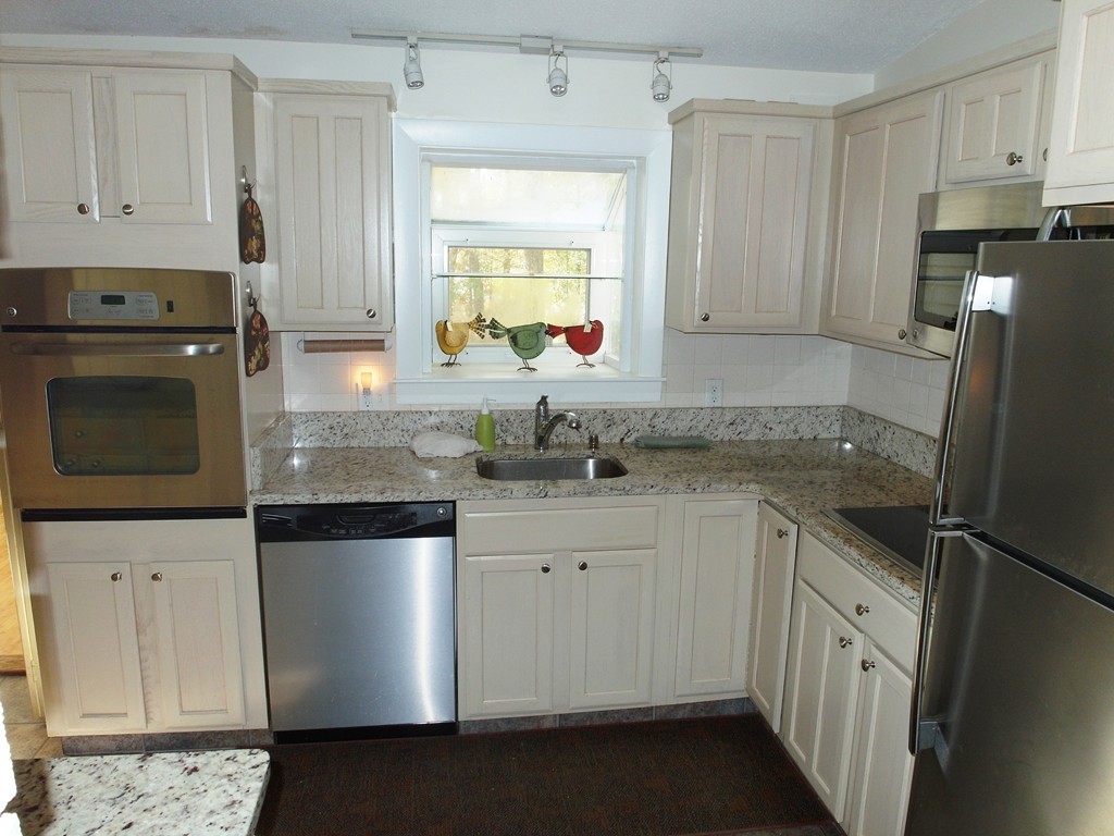 3 Orchard Road Ashland, MA 01721 - Photo 4 of 28 a kitchen with granite countertop white cabinets white stainless steel appliances and a sink
