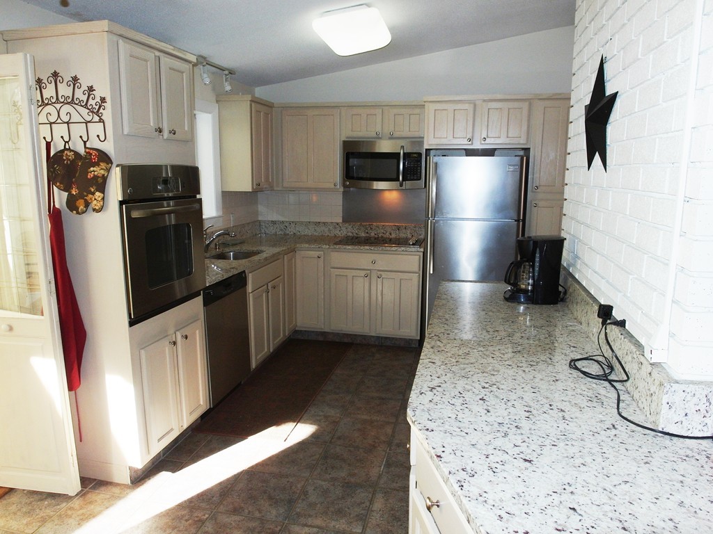 3 Orchard Road Ashland, MA 01721 - Photo 5 of 28 a kitchen with stainless steel appliances granite countertop a refrigerator a stove top oven a sink and dishwasher