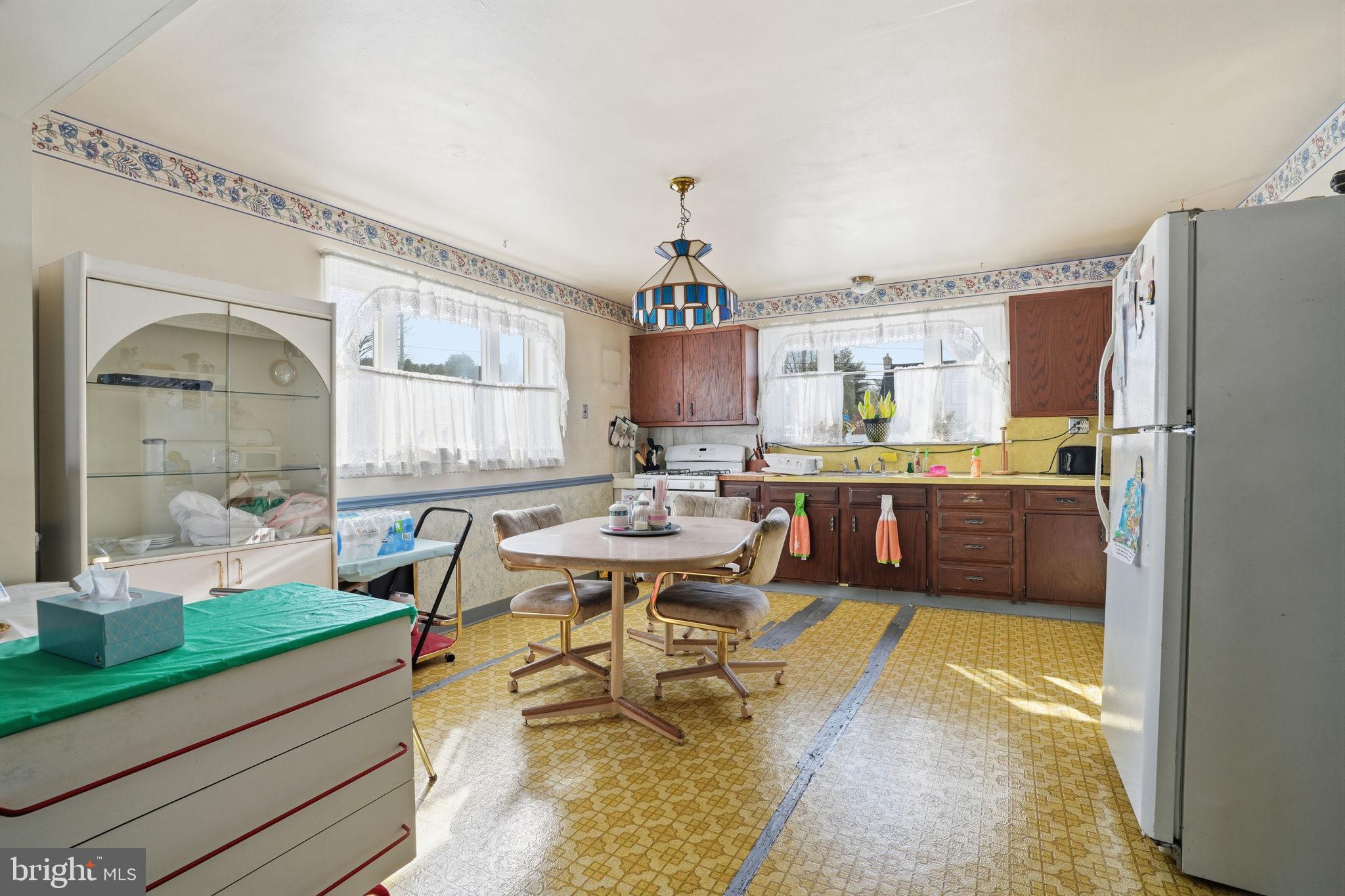 443 Ridge Pike Lafayette Hill, PA 19444 - Photo 13 of 13 a kitchen with a sink dishwasher a dining table and chairs with wooden floor