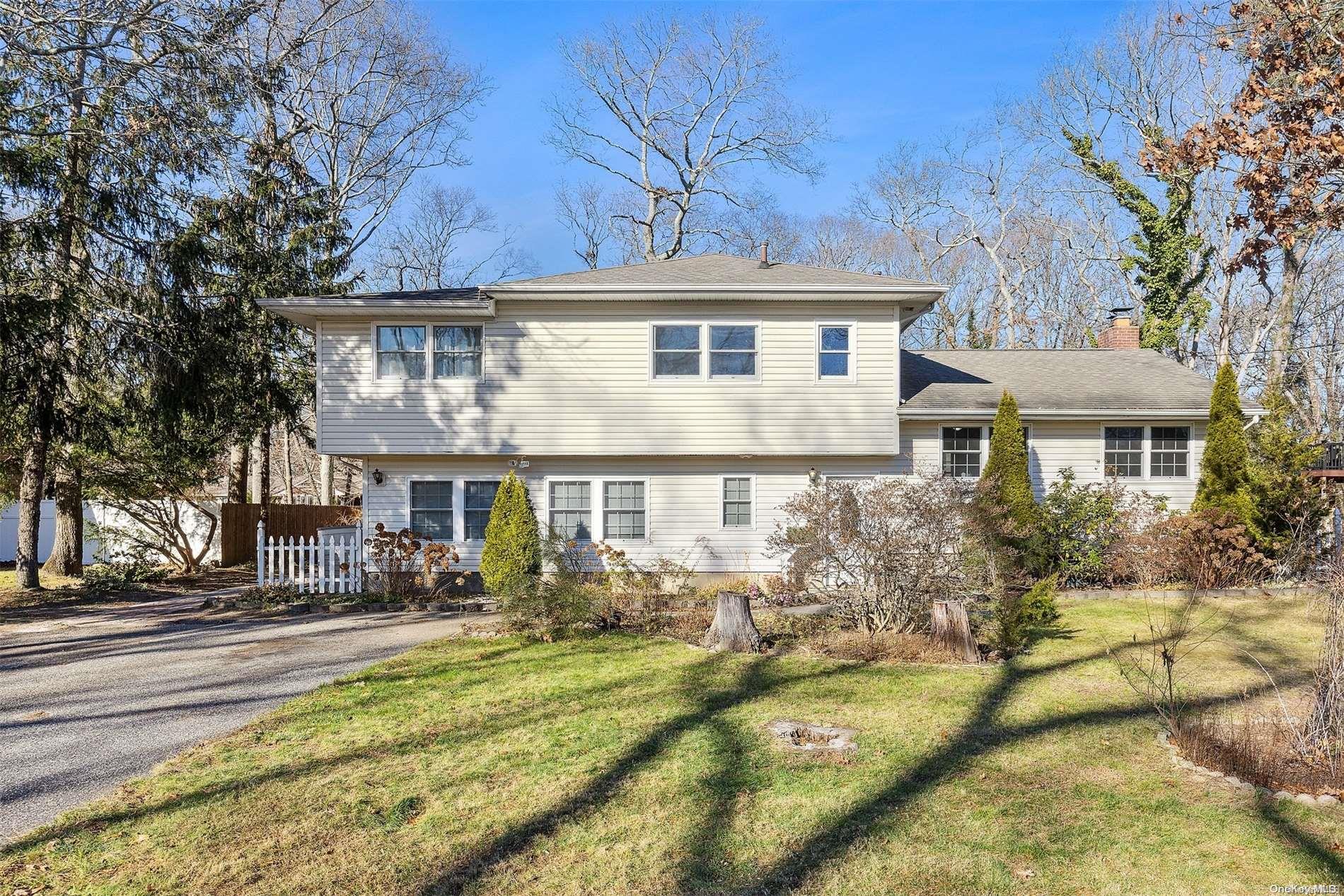 a front view of house with yard and trees around