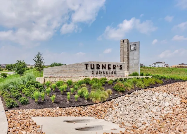a sign board with a house in the background