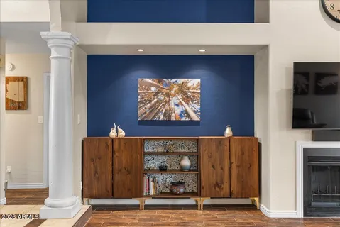 a living room with couches a large window and a clock