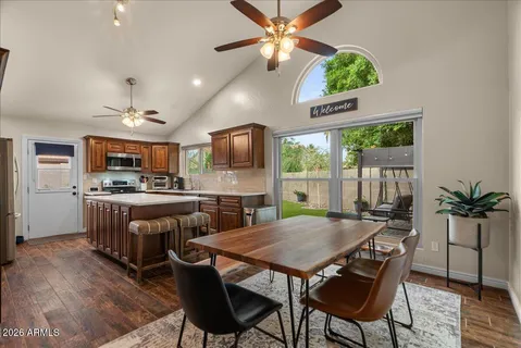 a kitchen with stainless steel appliances granite countertop a sink dishwasher and a refrigerator with wooden floor
