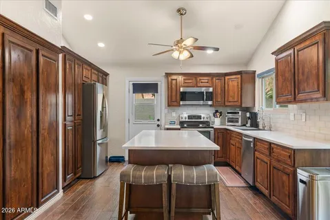 a kitchen with stainless steel appliances granite countertop a stove a sink and a microwave