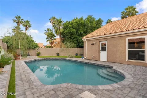 an aerial view of a house with swimming pool and outdoor seating