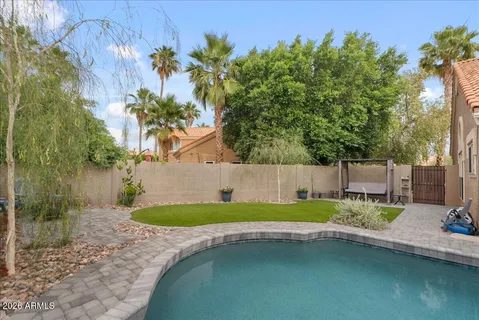 a view of a house with a swimming pool and a yard