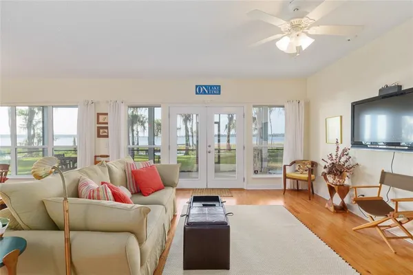 a dining room with furniture a chandelier and wooden floor