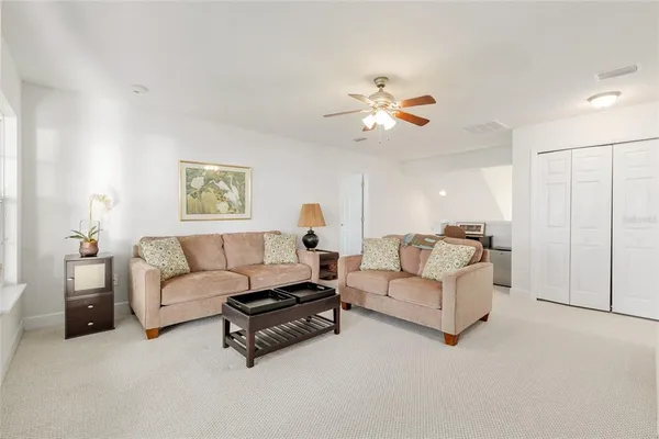 a living room with furniture a flat screen tv and kitchen view