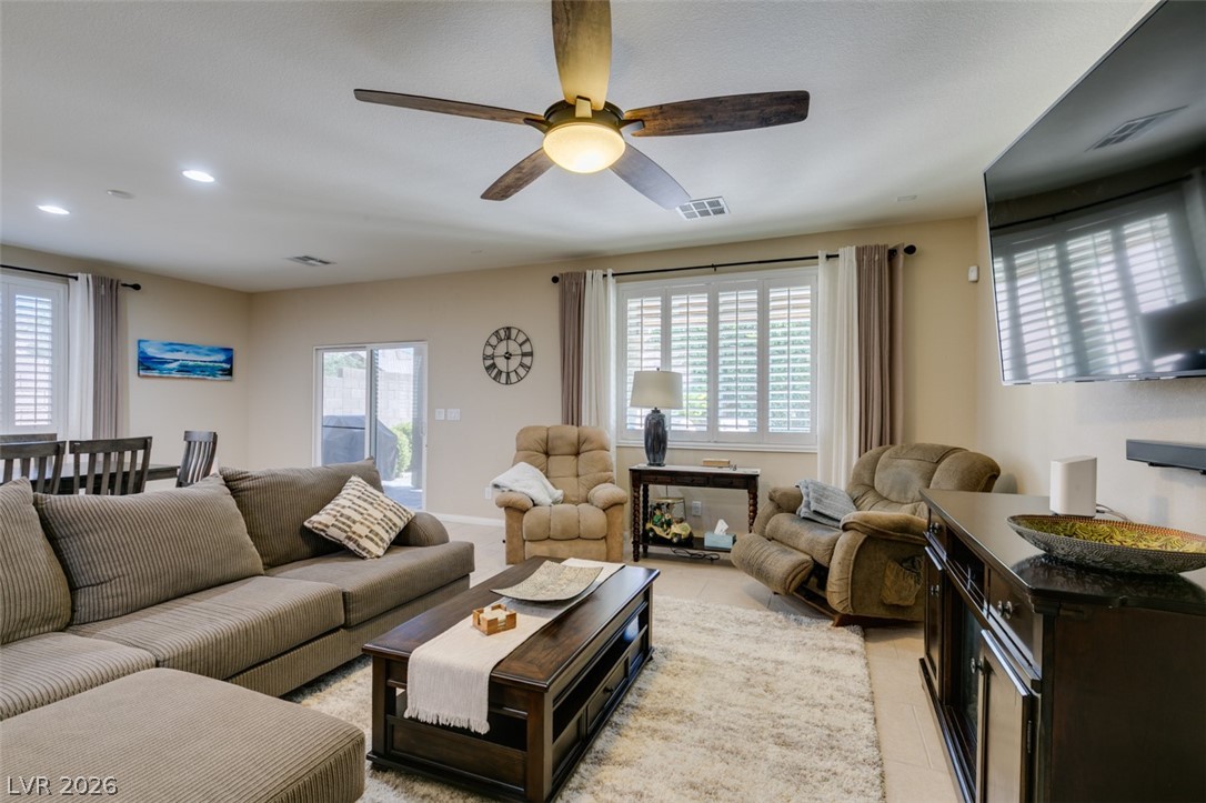 7375 Campbell Ranch Avenue Las Vegas, NV 89179 - Photo 18 of 45 Relax in this inviting living space, complete with a modern ceiling fan and ample natural light from the large window.