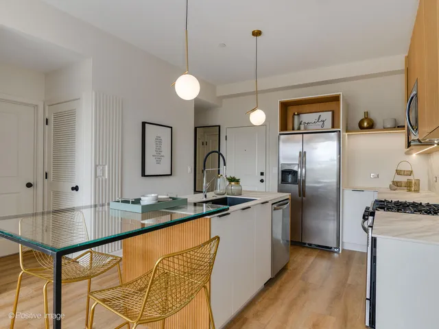 a kitchen with stainless steel appliances granite countertop a sink a stove and refrigerator