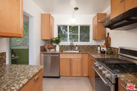a kitchen with stainless steel appliances granite countertop a refrigerator and a stove top oven