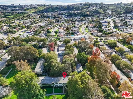 an aerial view of a house with a yard and mountain view in back