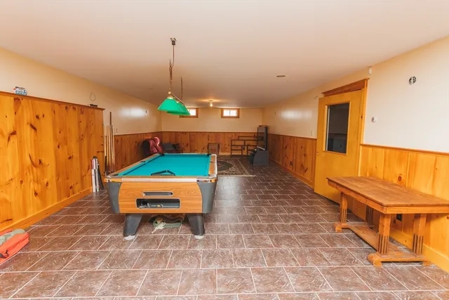 a room with pool table and chairs