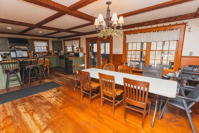 a dining room with furniture a chandelier and wooden floor