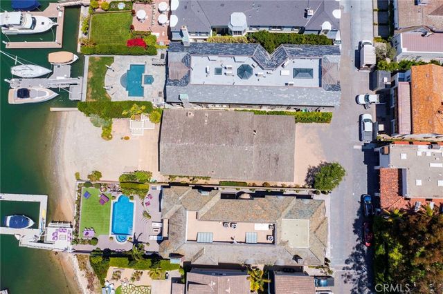 an aerial view of a house with lots of space swimming pool and ocean view