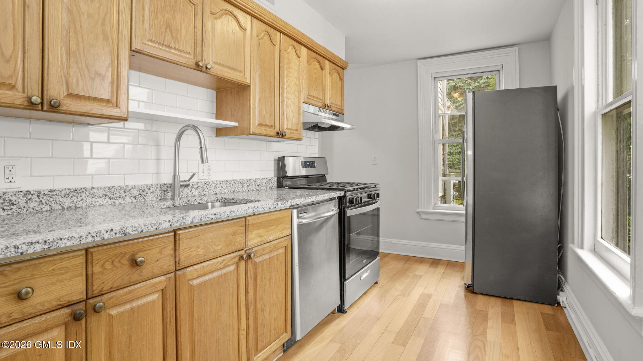 43 Church Street, Unit 1 Greenwich, CT 06830 - Photo 7 of 17 a kitchen with granite countertop a refrigerator a sink a stove and cabinets