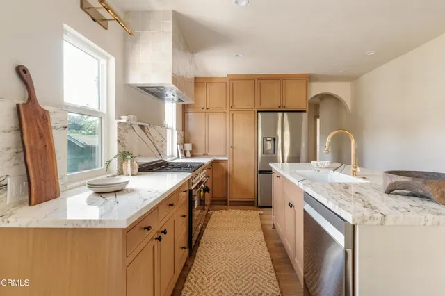 a kitchen with granite countertop a sink stove and refrigerator