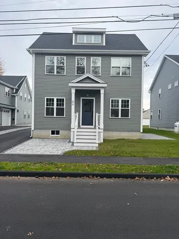 a front view of a house with a garden and yard