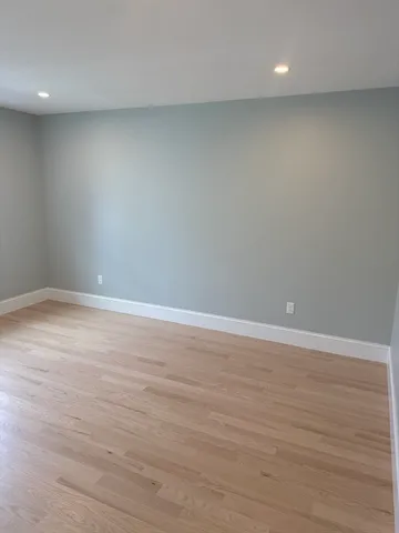an empty room with wooden floor and white walls