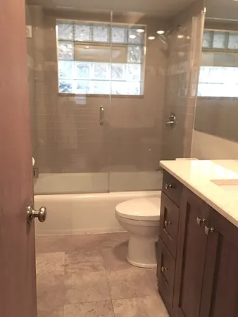 a bathroom with a granite countertop sink toilet and shower