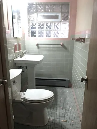 a bathroom with a sink a toilet and a window