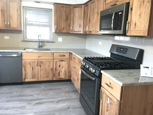 a kitchen with granite countertop a sink stove and cabinets