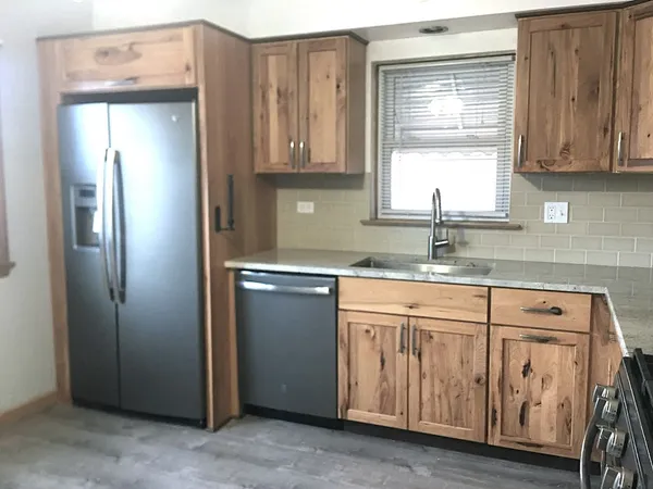 a kitchen with stainless steel appliances granite countertop a refrigerator and a sink