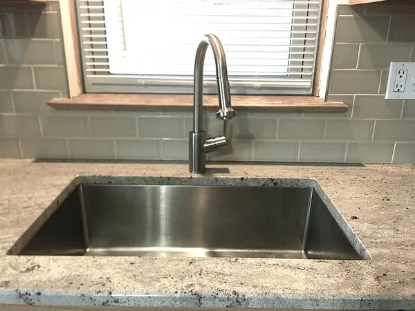 a view of a kitchen with a sink and wooden cabinets
