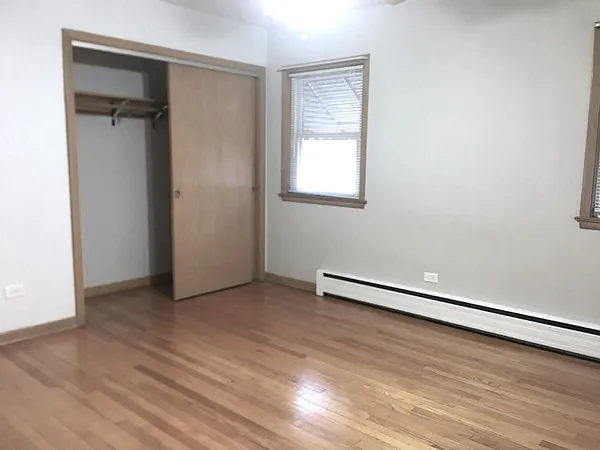 an empty room with wooden floor and a window