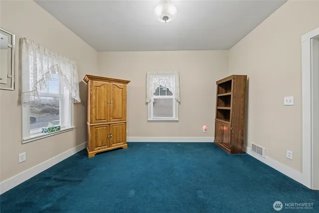 a view of an empty room with a window and workspace