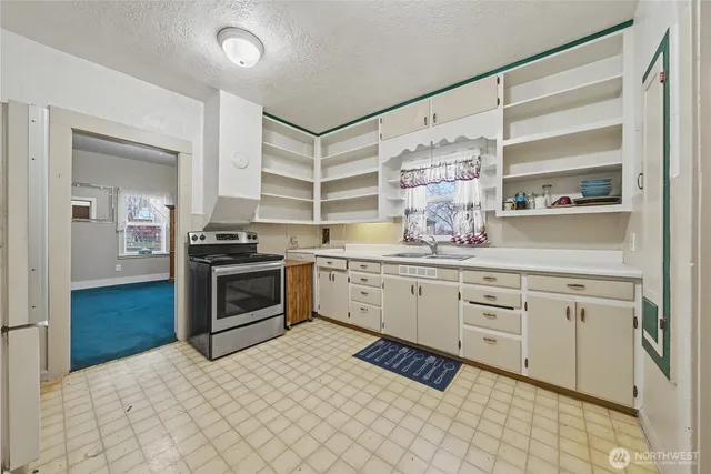 a kitchen with a stove a sink and a refrigerator