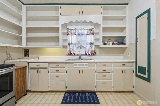 a kitchen with granite countertop white cabinets and stainless steel appliances