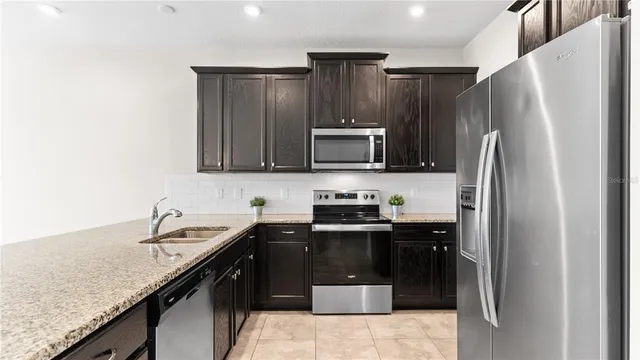 a kitchen with a sink a stove top oven and refrigerator