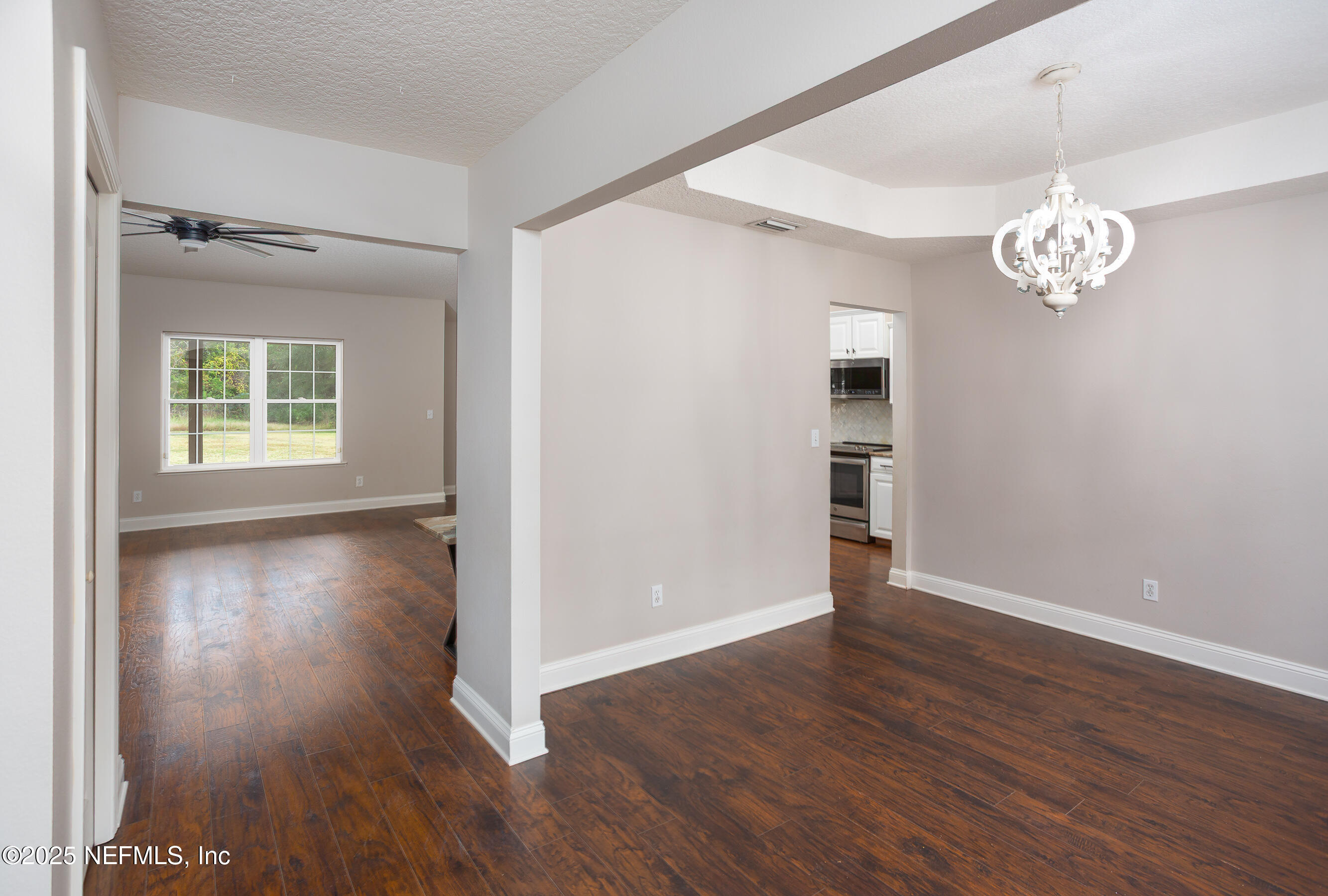 194 Horseman Club Road Palatka, FL 32177 - Photo 8 of 27 an empty room with wooden floor and windows