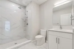 a bathroom with a granite countertop sink a toilet and a shower