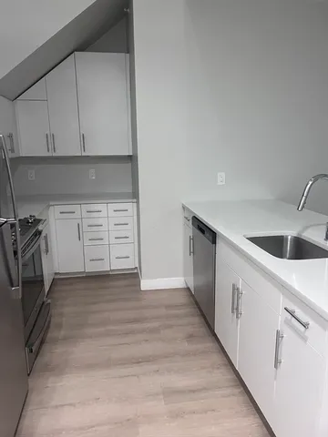 a kitchen with granite countertop white cabinets and white appliances