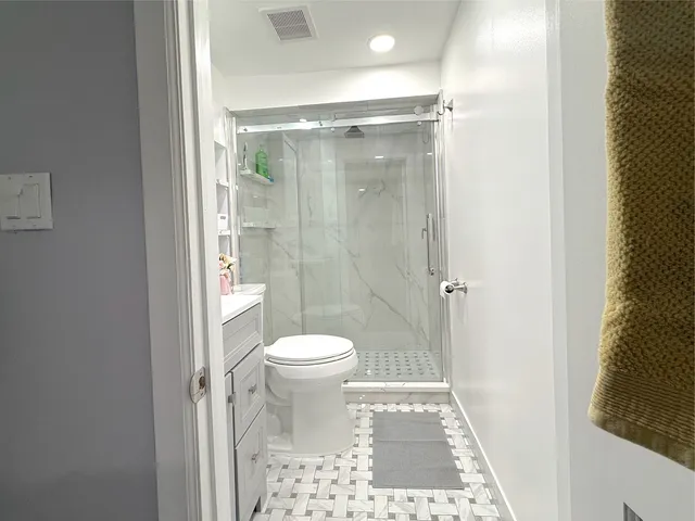 a bathroom with a toilet and a shower