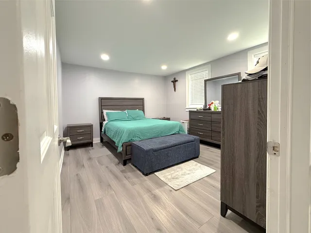 a bedroom with a bed window and a mirror