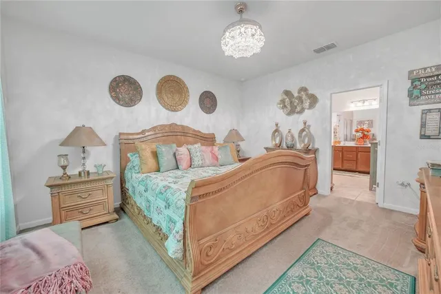 a bedroom with a bed and a chandelier