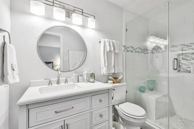 a bathroom with a double vanity sink toilet and shower