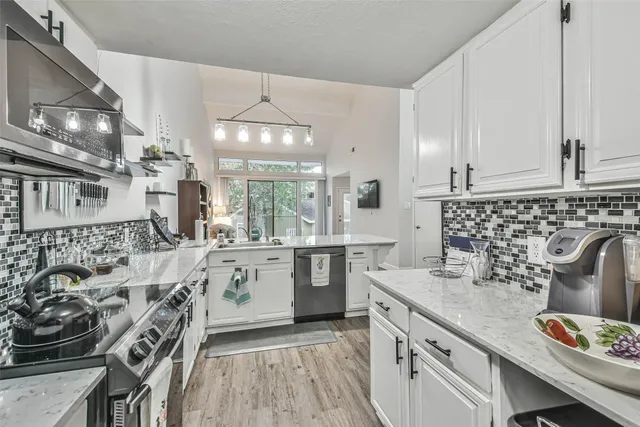 a kitchen with stainless steel appliances granite countertop a sink stove and cabinets
