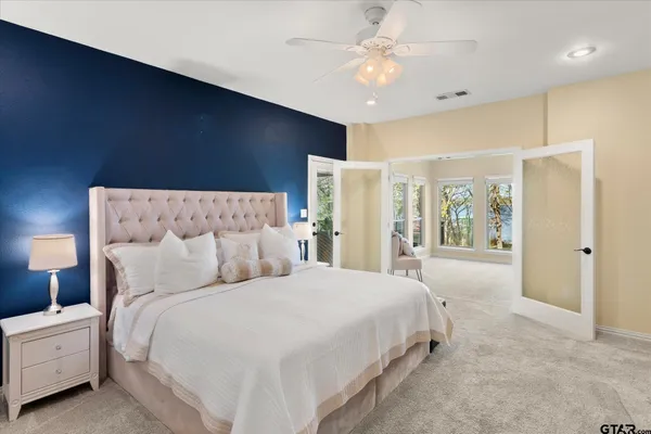 a spacious bedroom with a large bed and a chandelier