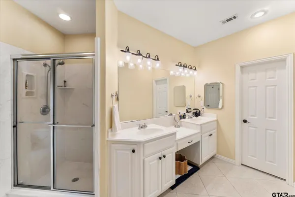 a spacious bathroom with a double vanity sink mirror and shower