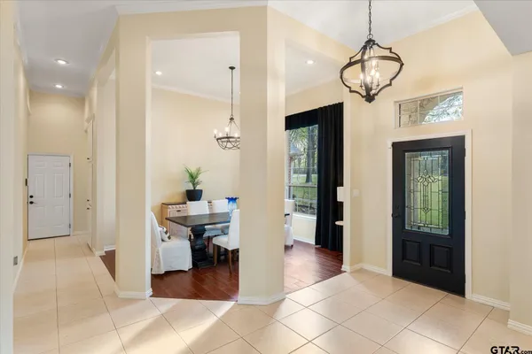 a view of a livingroom and a chandelier fan windows and entryway