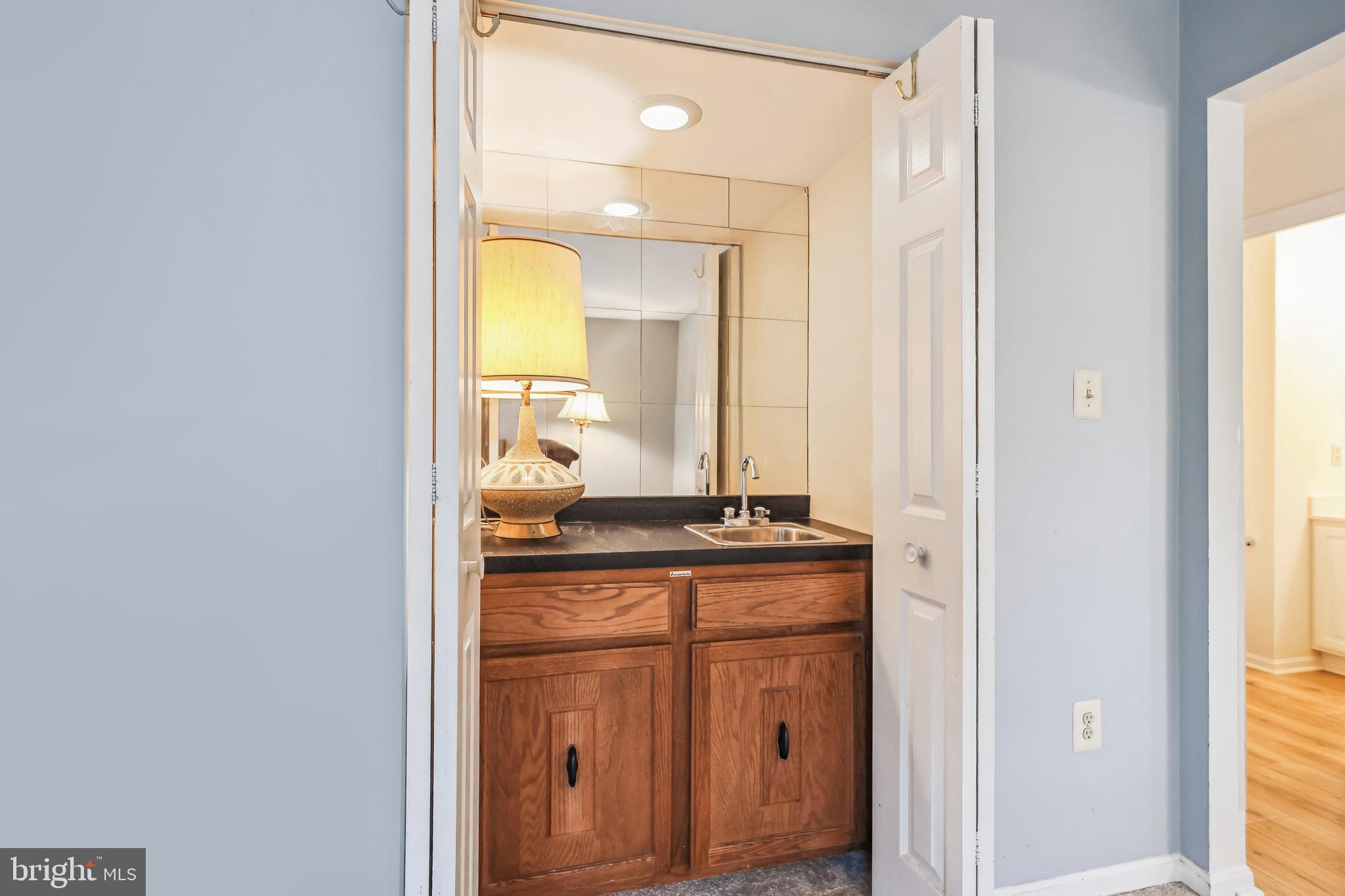 7122 Rolling Forest Avenue Springfield, VA 22152 - Photo 22 of 58 a bathroom with a granite countertop sink and a mirror
