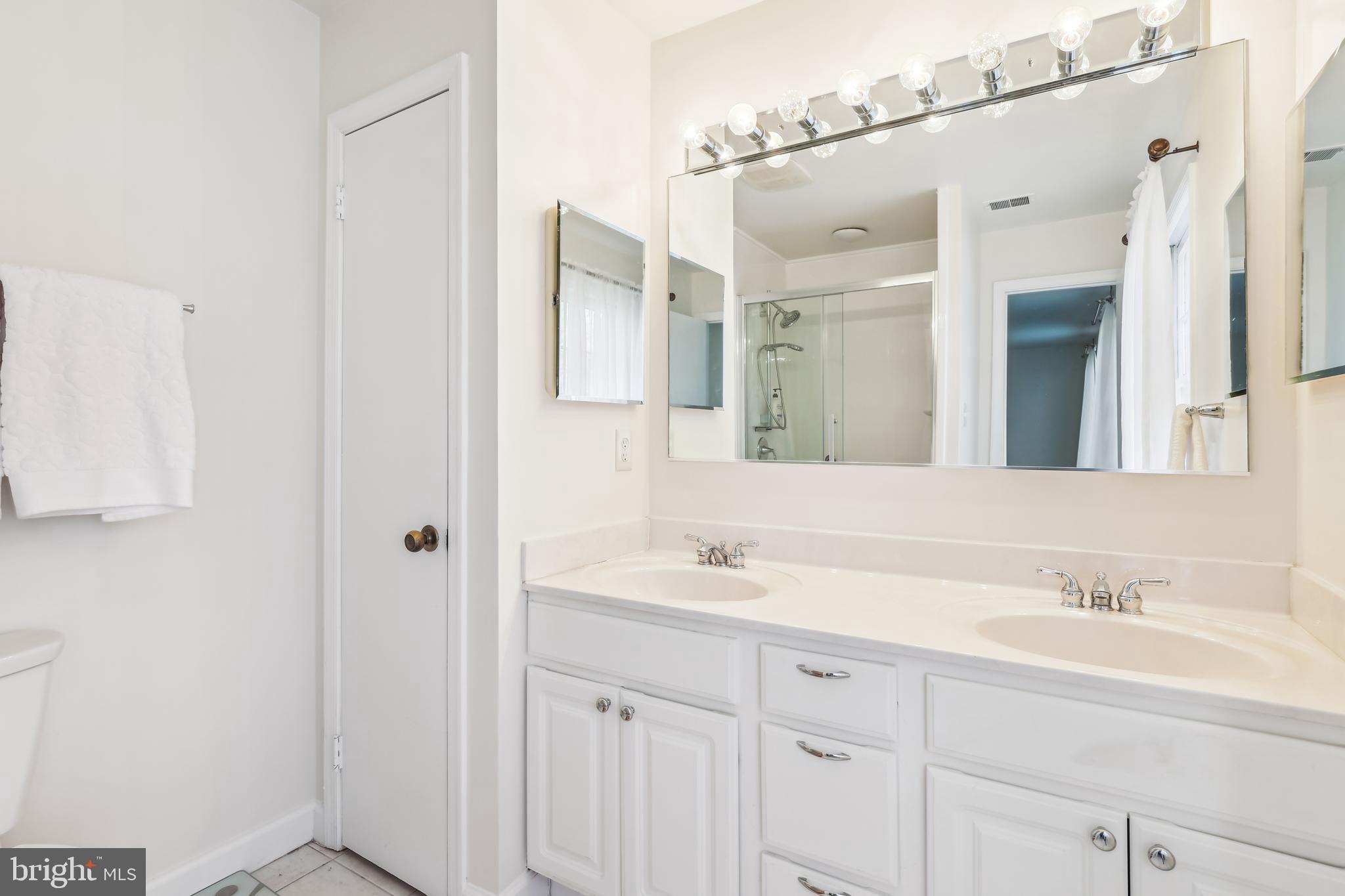 7122 Rolling Forest Avenue Springfield, VA 22152 - Photo 32 of 58 a bathroom with a sink double vanity and a mirror