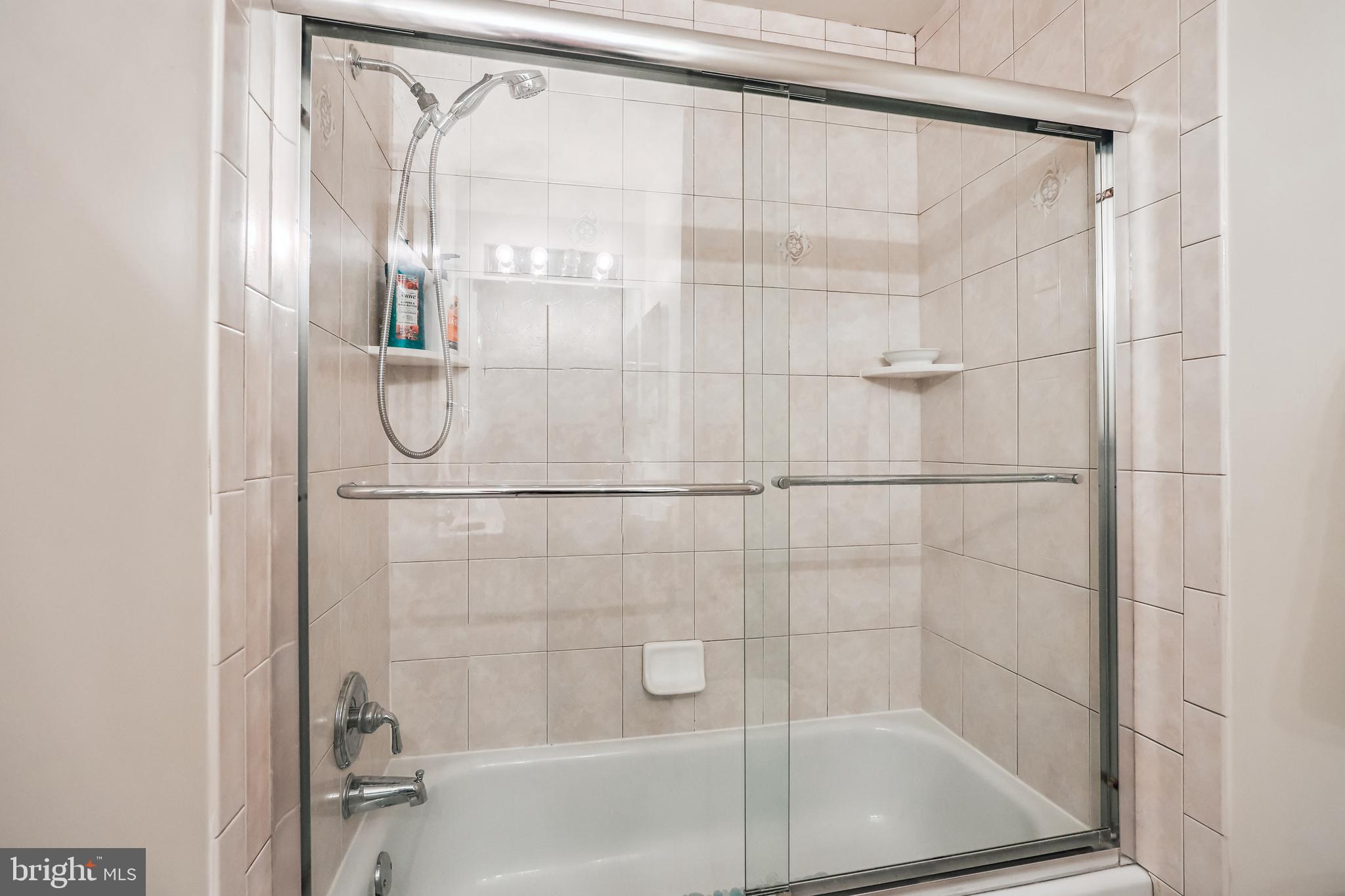 7122 Rolling Forest Avenue Springfield, VA 22152 - Photo 42 of 58 a bathroom with a glass shower door