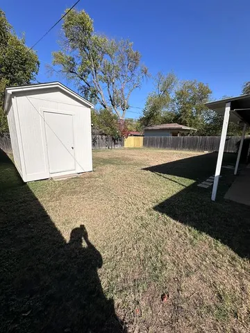 a view of backyard with wooden fence